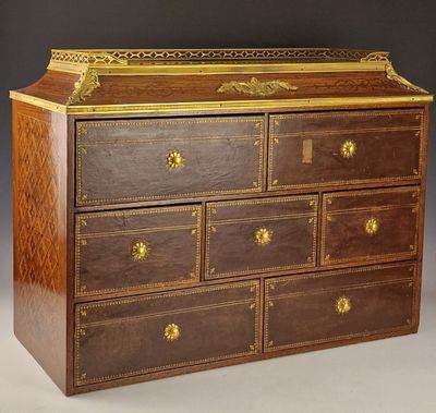 une commode ancienne en bois ornée de garnitures dorées