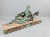 statue of a woman sitting on a wooden base with a bird on her lap