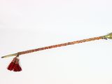 une vieille pipe en laiton dont l'extrémité est ornée d'un pompon rouge