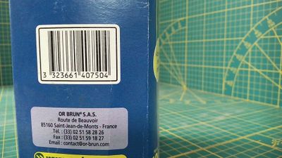 une boîte bleue sur laquelle figure un code-barres, posée sur une table