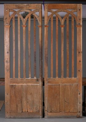 une paire de portes anciennes en bois avec des panneaux de vitraux et un banc