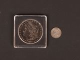 a close up of a coin and a small coin on a black surface