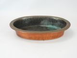 a small copper bowl on a white surface