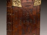 an old leather book with gold trimmings and a cross on the front
