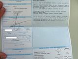 une personne tenant un papier sur lequel figure la photo d'une personne