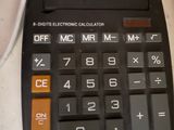 a calculator sitting on a counter next to a mouse