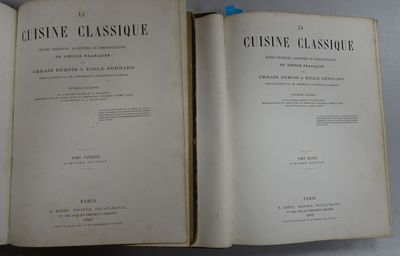an open book sitting on top of a table next to another open book