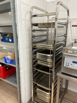 a metal rack with trays of food in a kitchen