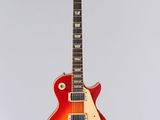 une guitare électrique accrochée à un mur sur fond blanc
