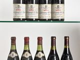 several bottles of wine sit on a glass shelf in front of a white wall