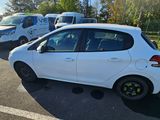 a small white car that is parked in a parking lot