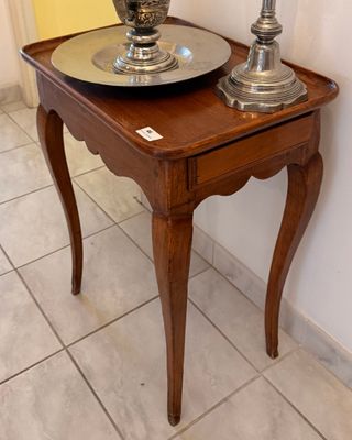 une petite table sur laquelle sont posés deux vases en argent
