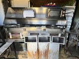 une cuisine équipée d'une cuisinière, d'un évier et d'autres appareils électroménagers