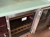 a green counter top with a wine cooler underneath it