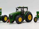 three toy tractors sitting side by side on a white surface