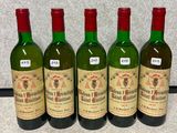 quatre bouteilles de vin sont alignées sur un comptoir