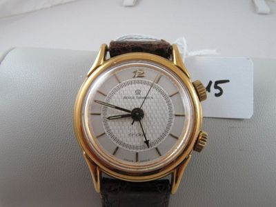 a gold wrist watch with a white dial on it