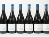 six bouteilles de vin sont alignées sur une table