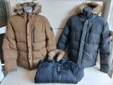 two jackets and a bag are sitting on a shelf in a store