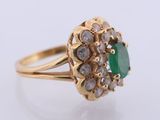 a close up of a gold ring with a green stone
