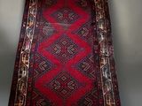 an oriental runner rug on a stand in a room