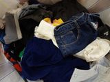 a pile of clothes in a basket on a bed