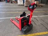 un chariot élévateur rouge garé sur le parking d'un entrepôt