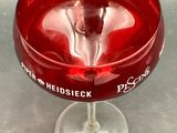 a wine glass with a red liquid inside of it