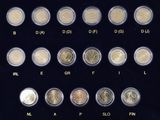 many different types of coins in a display case