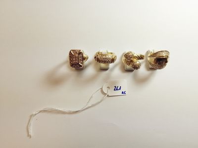 three pieces of silver and gold jewelry on a white surface