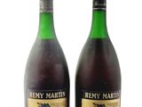 two bottles of wine sitting next to each other on a white surface