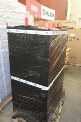 une pile de boîtes noires posées sur une palette dans un entrepôt