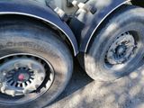 two tires on a flatbed truck parked on the side of the road