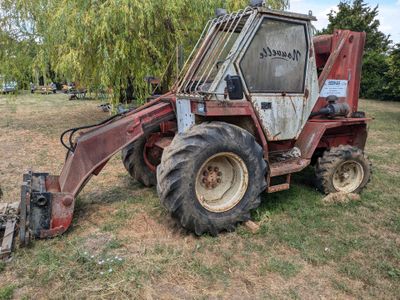 un tracteur rouge garé dans l'herbe
