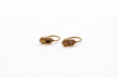 une paire de boucles d'oreilles en or sur fond blanc