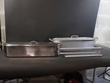 two pans sitting on a table in front of a backdrop