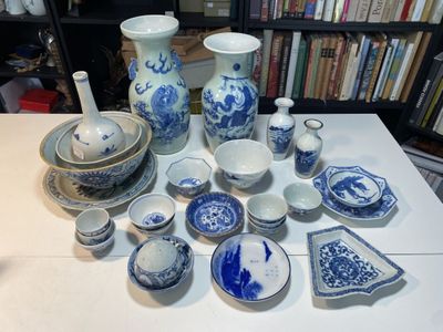 une table sur laquelle sont disposés de nombreux plats bleus et blancs