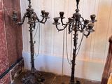 two antique candelabs sitting next to each other on the floor