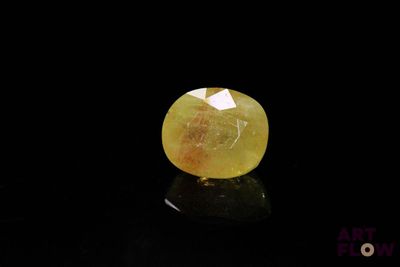 un diamant jaune sur une surface noire