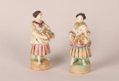 pair of porcelain figurines of a woman holding a child