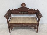 an old wooden bench with a cushion on top of it