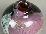 a purple and black vase sitting on a table