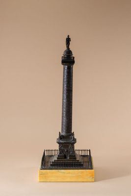 a bronze statue of a lighthouse on a wooden base