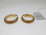 une paire de boucles d'oreilles en or sur fond blanc