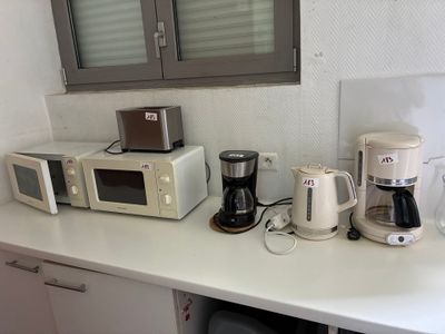 Il y a de nombreux types d'appareils électroménagers posés sur le plan de travail de cette cuisine