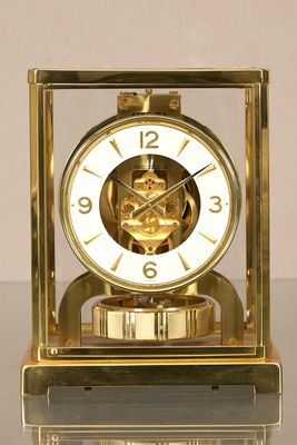 une horloge en or posée sur une table en verre