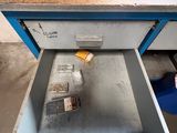 an open drawer with a metal object inside of it