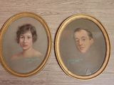two framed portraits of a woman and a man on a table