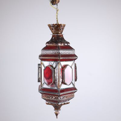 a close up of a red and gold lantern hanging from a ceiling