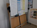 a whiteboard on a stand in the corner of a room